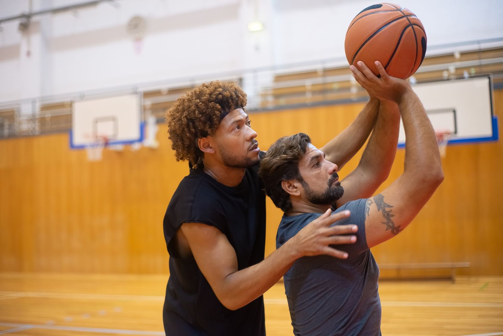 Basketbol maçını tribünden izleyen taraftarlar ve ışıklandırılmış basketbol sahası